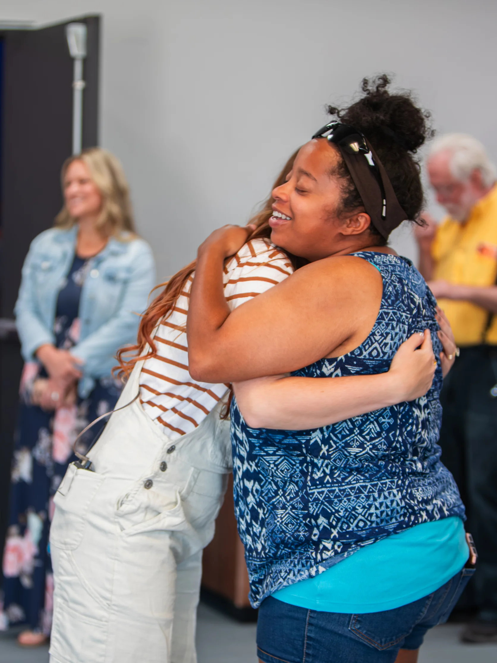 Two women embracing at Good News Co.